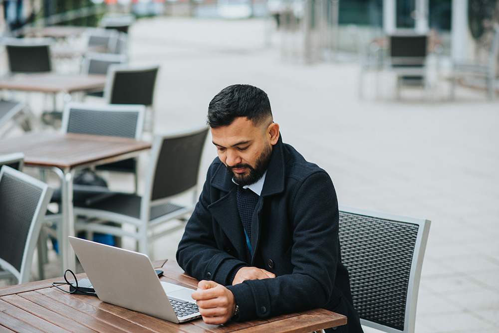 man at table looking at laptop